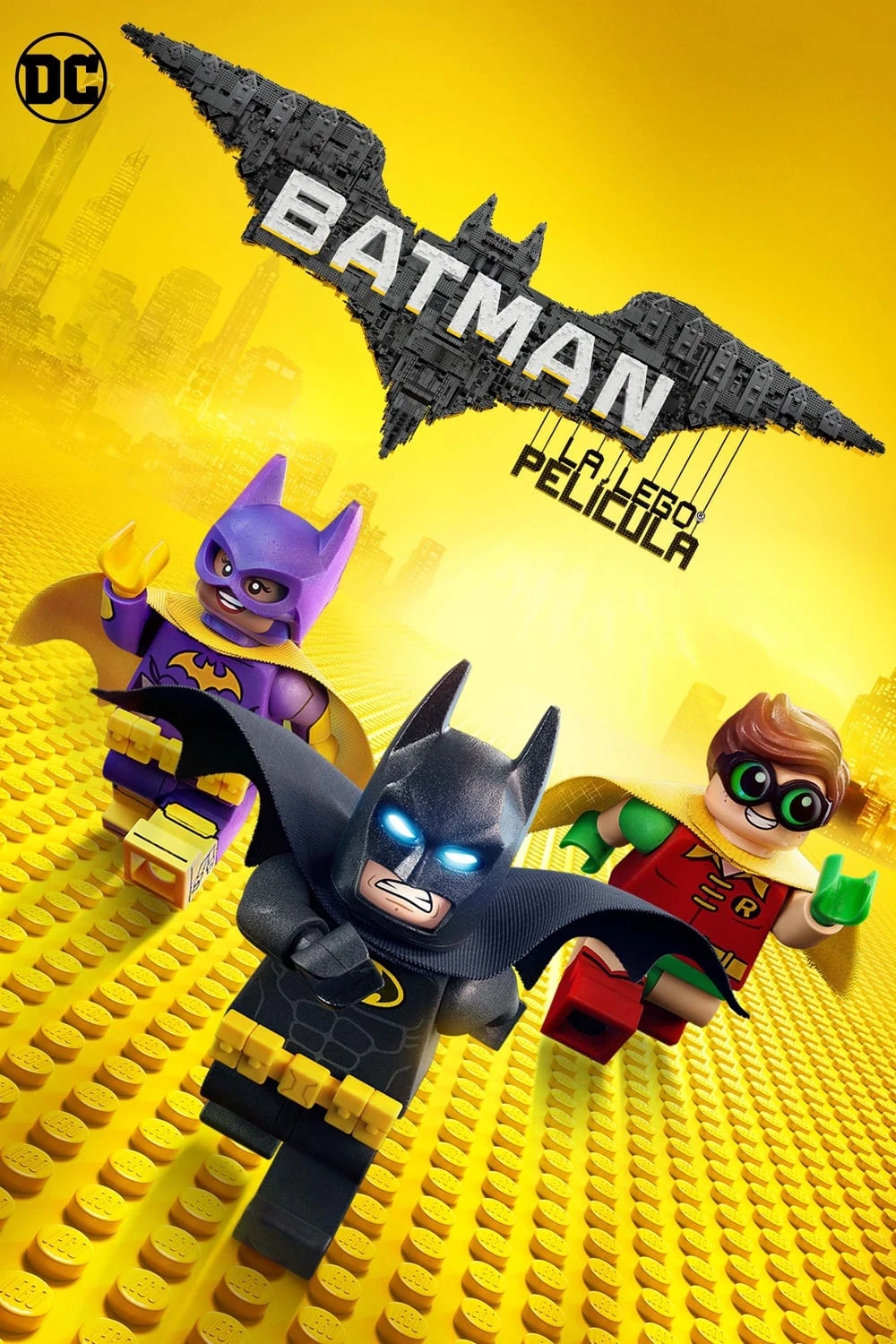 Cartel español de Batman: La LEGO película: las figuras de LEGO de Batman, Batgirl y Robin corren sobre piezas amarillas bajo un murciélago gigante hecho de bloques con el título