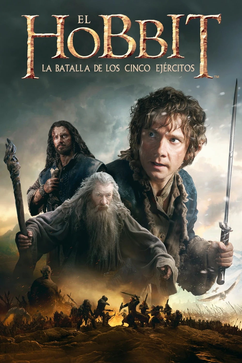 Cartel en español de El Hobbit: La batalla de los Cinco Ejércitos: Bilbo en primer plano con Gandalf y Thorin detrás y un campo de batalla en llamas al fondo