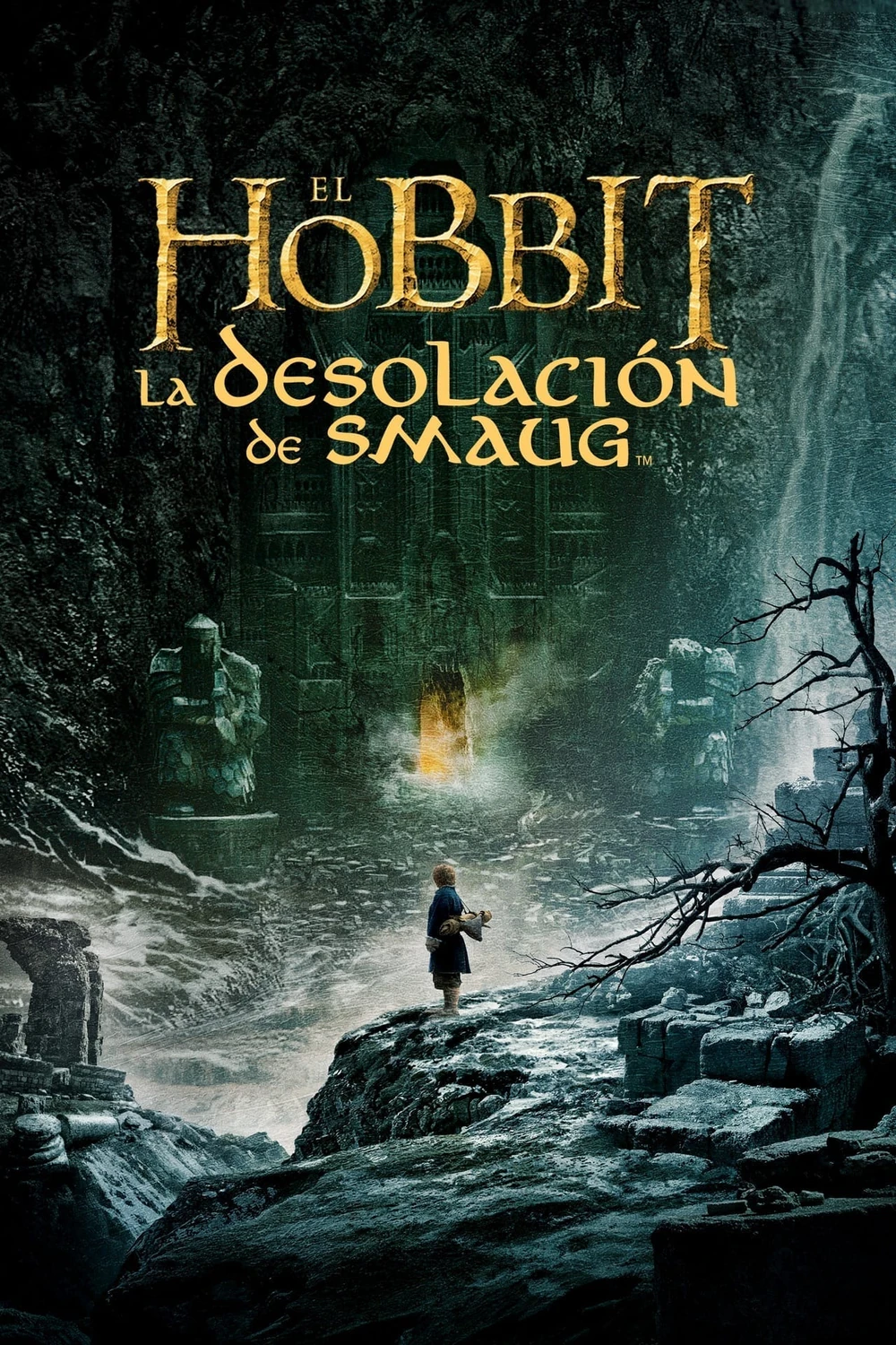 Cartel en español de El Hobbit: La desolación de Smaug: una figura diminuta sobre unas rocas ante una enorme puerta de piedra iluminada, en un paisaje oscuro y boscoso