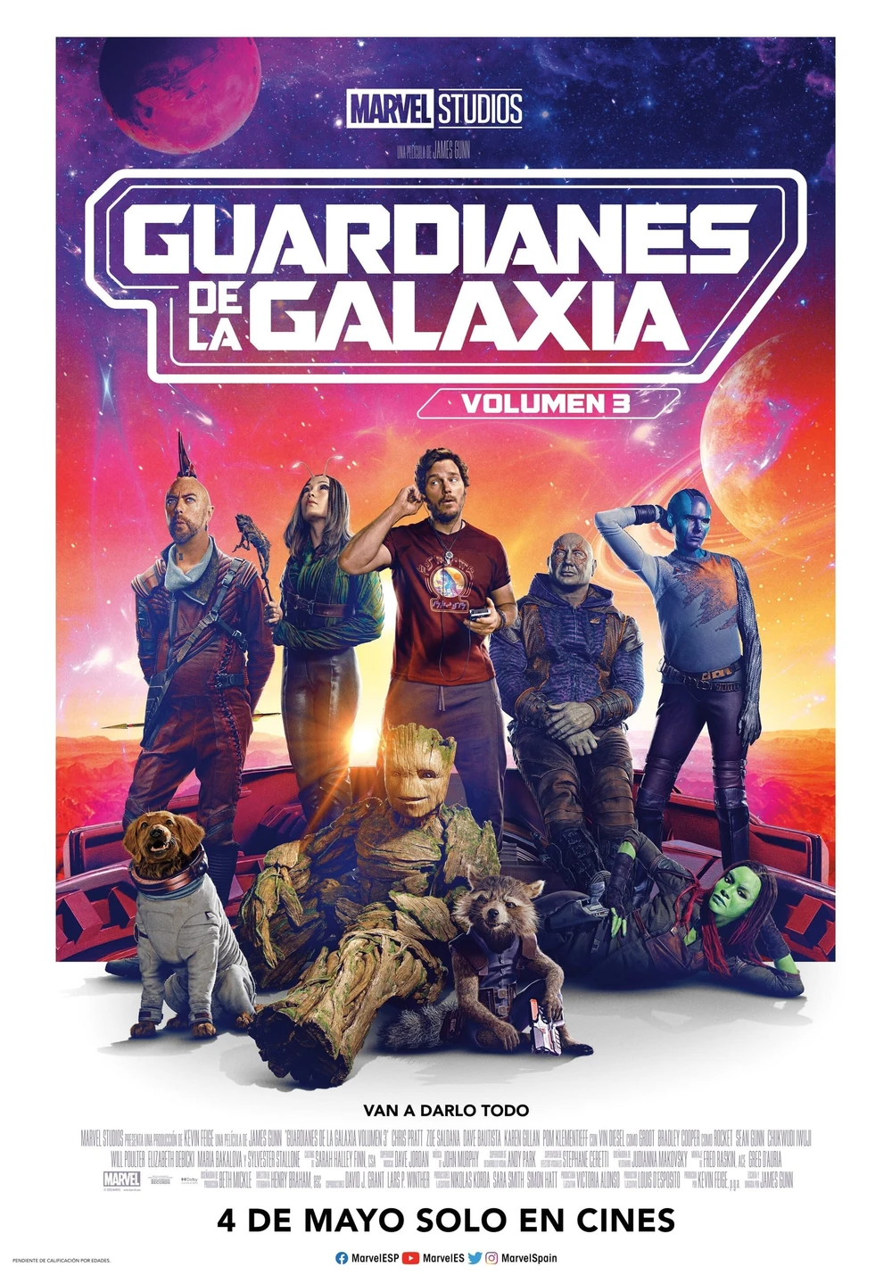 Cartel español de Guardianes de la Galaxia: Volumen 3: los Guardianes posan en fila ante un cielo rojo y morado con planetas; delante, Groot sentado, Rocket y un perro con traje espacial; debajo, «4 de mayo solo en cines»