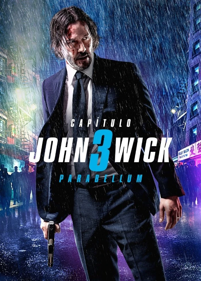 Cartel español de John Wick: Capítulo 3 - Parabellum: Keanu Reeves, empapado y con traje, sostiene una pistola bajo la lluvia en una calle con carteles de neón