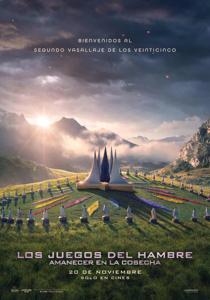 Cartel español de Amanecer en la cosecha: un valle verde entre montañas al amanecer, con una estructura de picos blancos en el centro rodeada de pedestales, y el texto «Bienvenidos al Segundo Vasallaje de los Veinticinco» y «20 de noviembre, solo en cines»