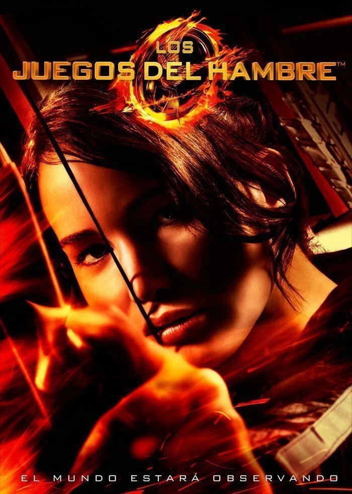 Cartel español de Los juegos del hambre: primer plano de Katniss Everdeen tensando un arco entre llamas, con el título arriba y la frase «El mundo estará observando» abajo