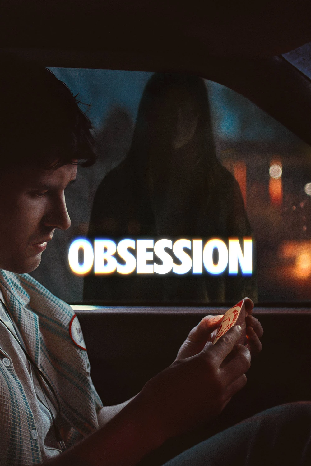 Cartel de Obsession: un chico sentado al volante de un coche de noche mira un pequeño objeto en su mano, mientras una figura de mujer se ve borrosa al otro lado de la ventanilla, con el título en letras blancas